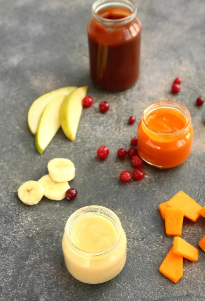 Jars with different healthy baby food on table — Stock Photo, Image