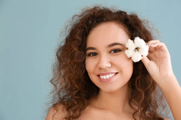 Hermosa mujer joven con flor de algodón sobre fondo de color — Foto de Stock