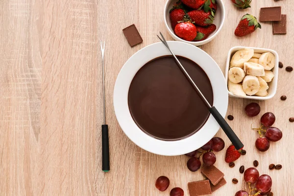 Cuenco con sabrosa fondue de chocolate y frutas en la mesa — Foto de Stock
