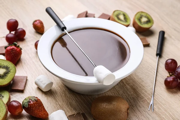 Schüssel mit leckerem Schokoladenfondue, Früchten und Eibisch auf dem Tisch — Stockfoto