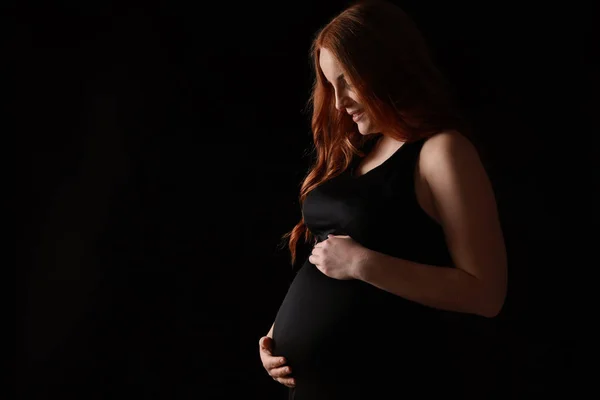 Frumos gravidă femeie pe fundal întunecat — Fotografie, imagine de stoc