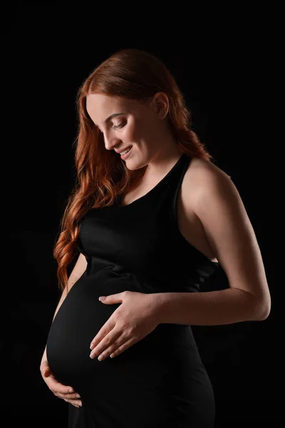 Vakker, gravid kvinne med mørk bakgrunn – stockfoto