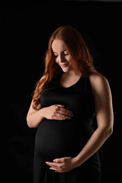 暗い背景に美しい妊娠中の女性 — ストック写真