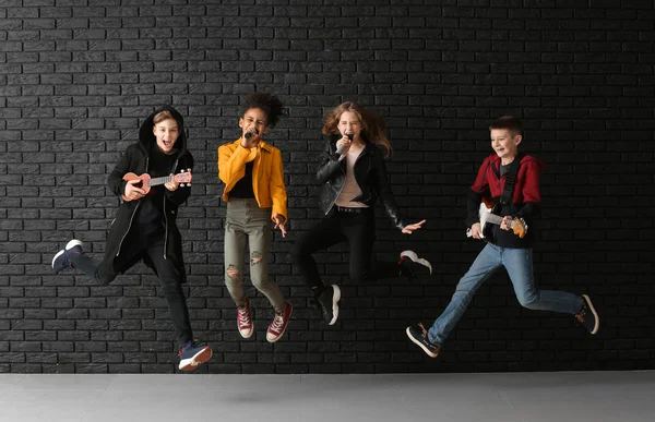 Hoppande band av tonårs musiker mot Dark Wall — Stockfoto