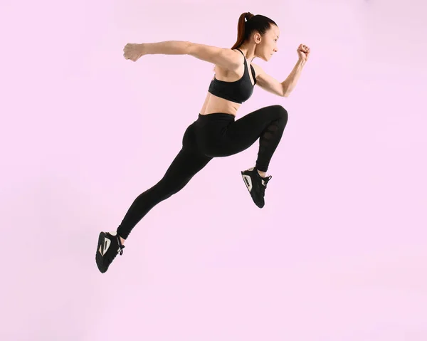 Sportlich laufende Frau auf farbigem Hintergrund — Stockfoto
