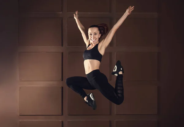Sportlich springende Frau auf farbigem Hintergrund — Stockfoto