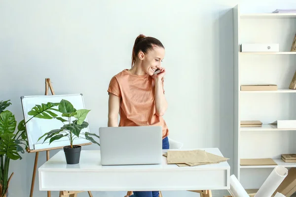 Woman talking by phone in office — Stock Photo, Image