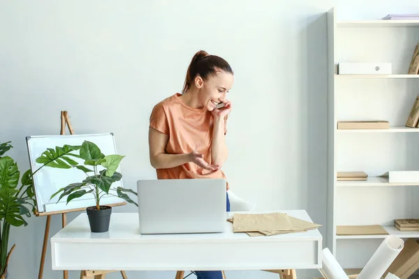 Woman talking by phone in office — Stock Photo, Image