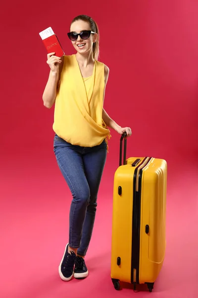 Female traveler with suitcase on color background — Stock Photo, Image