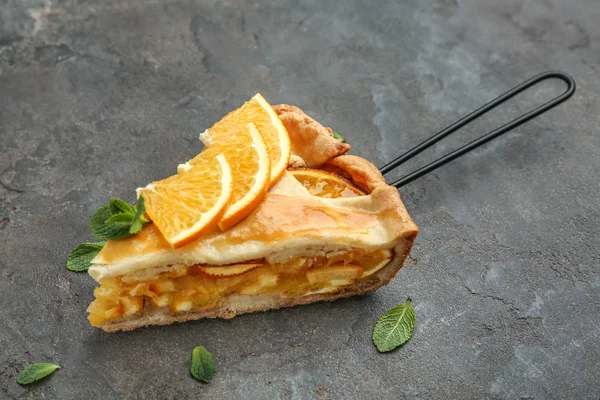 Piece of tasty orange pie on grey background — Stock Photo, Image