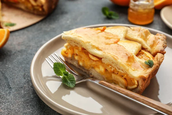 Plate with piece of tasty orange pie on table, closeup — Stock Photo, Image