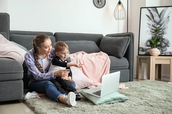 Молодая мать с маленьким сыном смотрит мультфильмы дома — стоковое фото