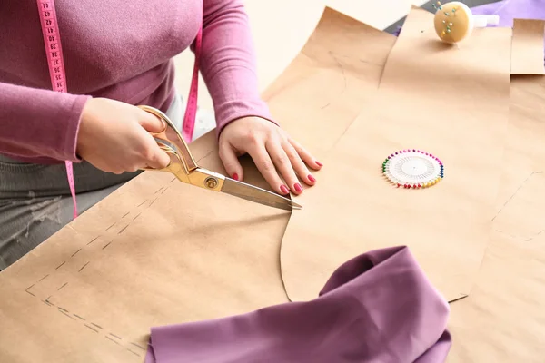 Female tailor working with sewing patterns in atelier — Stock Photo, Image