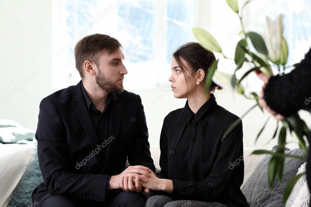 Couple pining after their relative at funeral