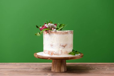 Renkli arka plan karşı masada çiçek dekorlu tatlı pasta