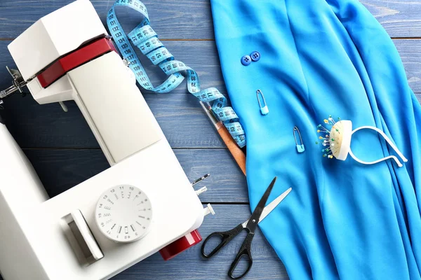 Pano com máquina de costura e acessórios de alfaiate no fundo de cor — Fotografia de Stock
