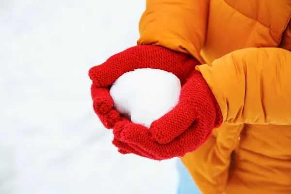 Woman holding heart made of snow on winter day — Stock Photo, Image