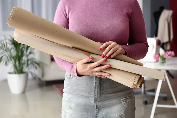 Female tailor with rolls of paper in atelier — Stock Photo, Image