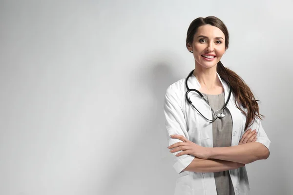 Female doctor on light background — Stock Photo, Image