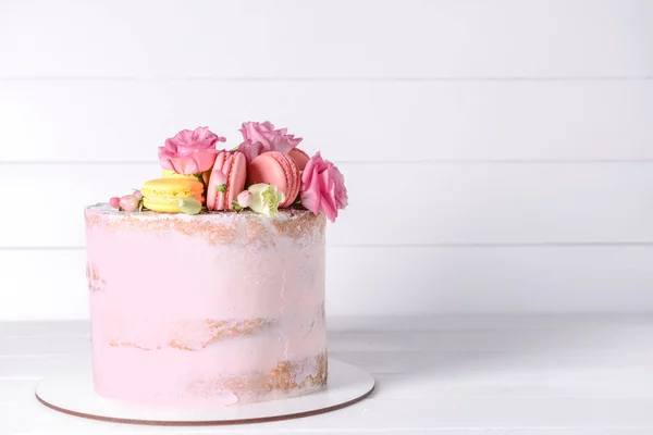 Sweet cake with floral decor on table — Stock Photo, Image