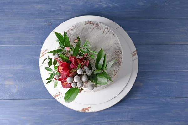 Sweet cake with floral decor on wooden table — Stock Photo, Image