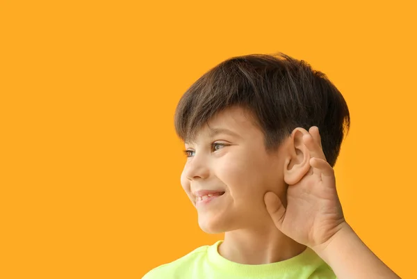 Niño pequeño con problemas de audición en el fondo de color —  Fotos de Stock