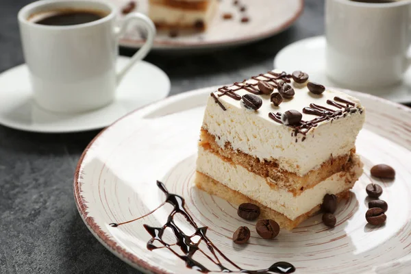 Piatto con gustoso tiramisù su tavola grigia — Foto Stock