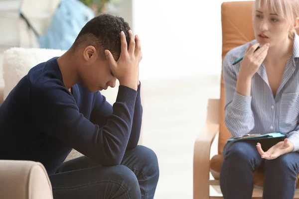 Psicóloga femenina que trabaja con un adolescente deprimido en la oficina — Foto de Stock