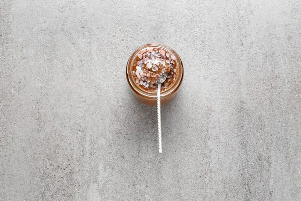 Jar of tasty salted caramel on grey background — Stock Photo, Image