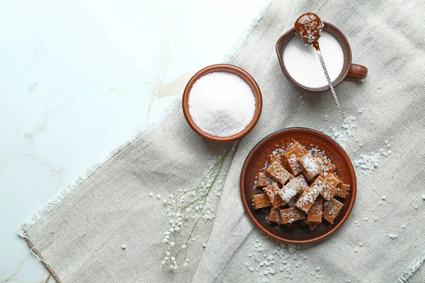 Tasty salty caramel candies with sugar and milk on table — Stock Photo, Image