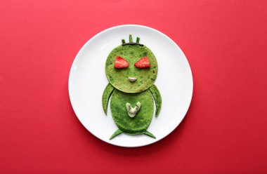 Renkli arka planda çocuk için lezzetli yeşil krep ile Plaka