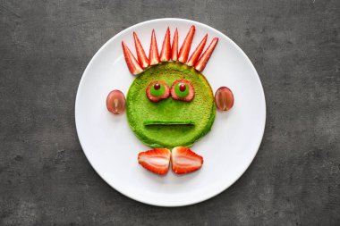 Gri arka plan üzerinde çocuk için lezzetli yeşil gözleme ile Plaka