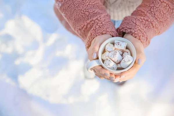 Γυναίκα που κρατά φλιτζάνι ζεστό κακάο με marshmallows χειμερινή ημέρα — Φωτογραφία Αρχείου