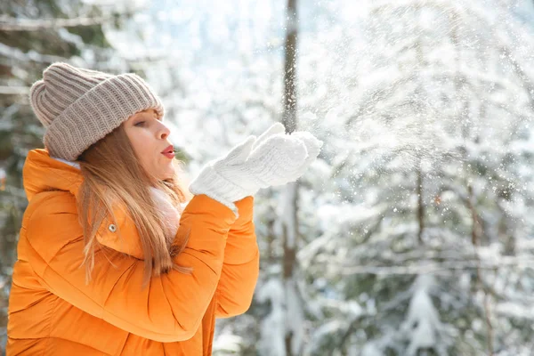 Beautiful woman playing with snow in winter forest — Stock Photo, Image