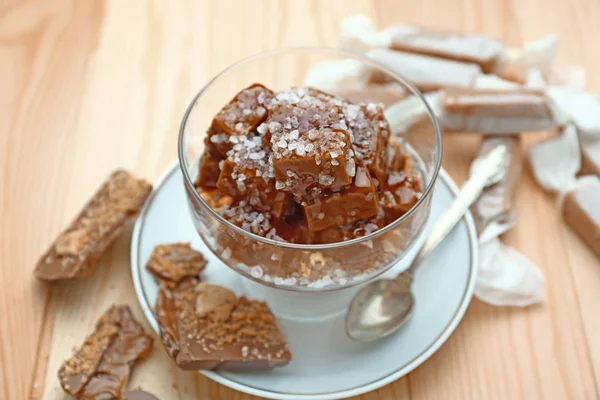 Tasty salted caramel on wooden table — Stock Photo, Image