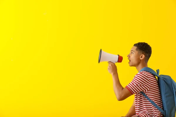 Retrato de adolescente afroamericano con megáfono sobre fondo de color — Foto de Stock