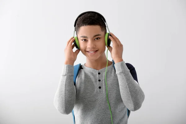 灰色の背景にヘッドフォンを持つアフリカ系アメリカ人の十代の少年の肖像画 — ストック写真