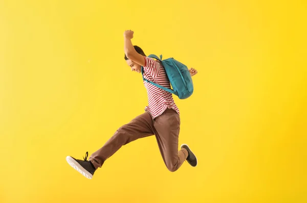 Portrait of jumping African-American teenage boy on color background — Stock Photo, Image