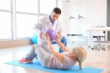 Rehabilitasyon merkezinde olgun hasta ile çalışan fizyoterapist