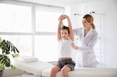 Rehabilitasyon merkezinde küçük kız ile çalışan fizyoterapist