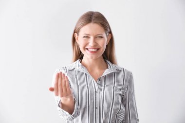 Güzel genç kadın ışık arka plan karşı izleyici davet