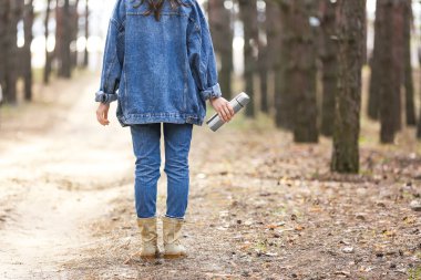 Ormanda dolaşan termoslu bir kadın.