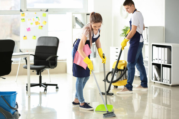 Female janitor cleaning office