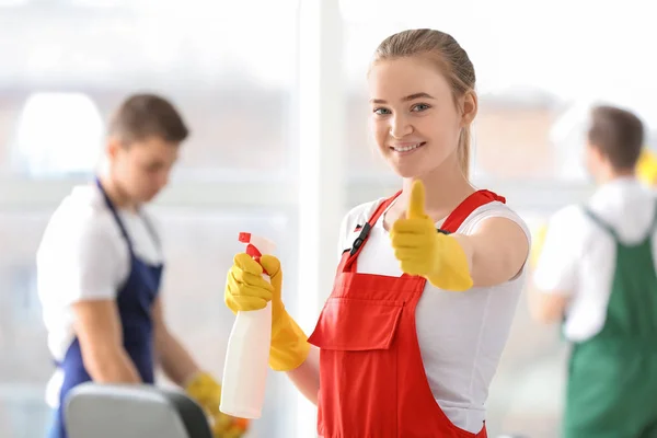 Petugas kebersihan wanita menunjukkan gerakan jempol di kantor — Stok Foto
