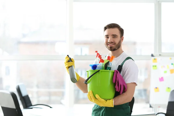 事務所で掃除用品を持つ男性清掃員 — ストック写真