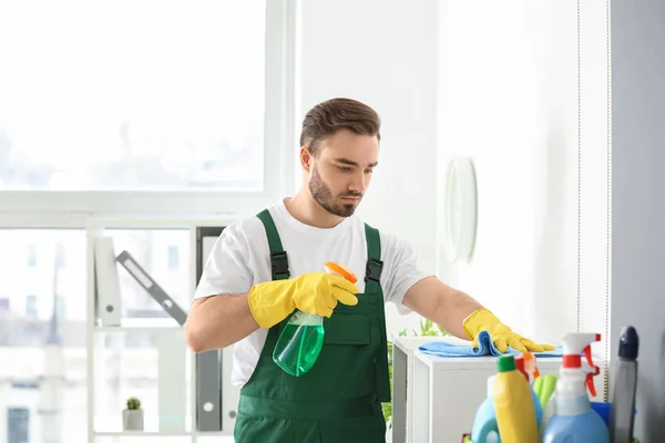 Conserje masculino limpiando estante en la oficina — Foto de Stock