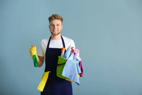 Portréja férfi gondnok a takarítási készletek a szürke háttér — Stock Fotó