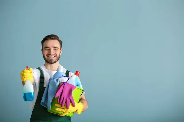 Portrait of male janitor with cleaning supplies on grey background — Stock Photo, Image