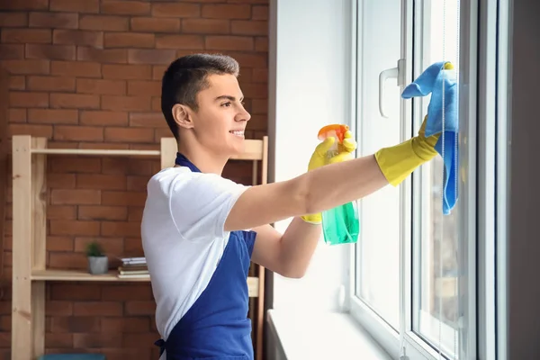 Conserje masculino limpiando ventana en la oficina — Foto de Stock