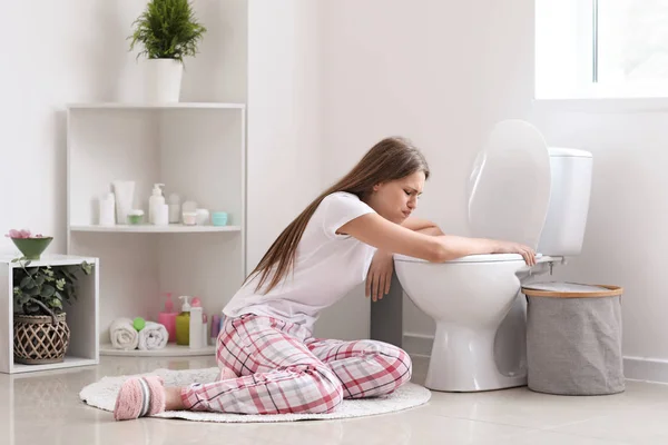 Pregnant woman suffering from toxicosis near toilet bowl in bathroom — Stock Photo, Image